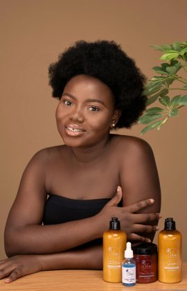 Portrait of a woman with skincare products, studio setting.