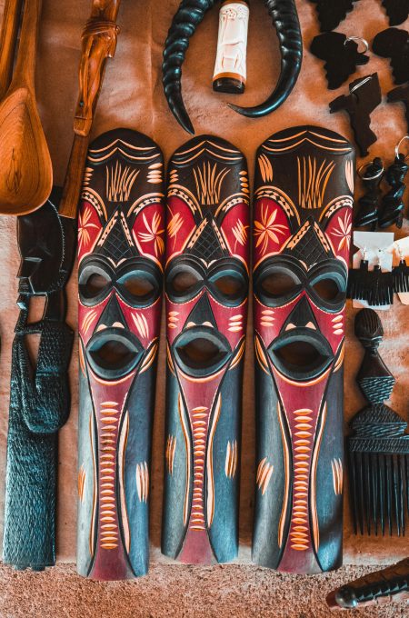 Vibrant tribal masks with intricate designs displayed alongside traditional decor items. Perfect for cultural themes.